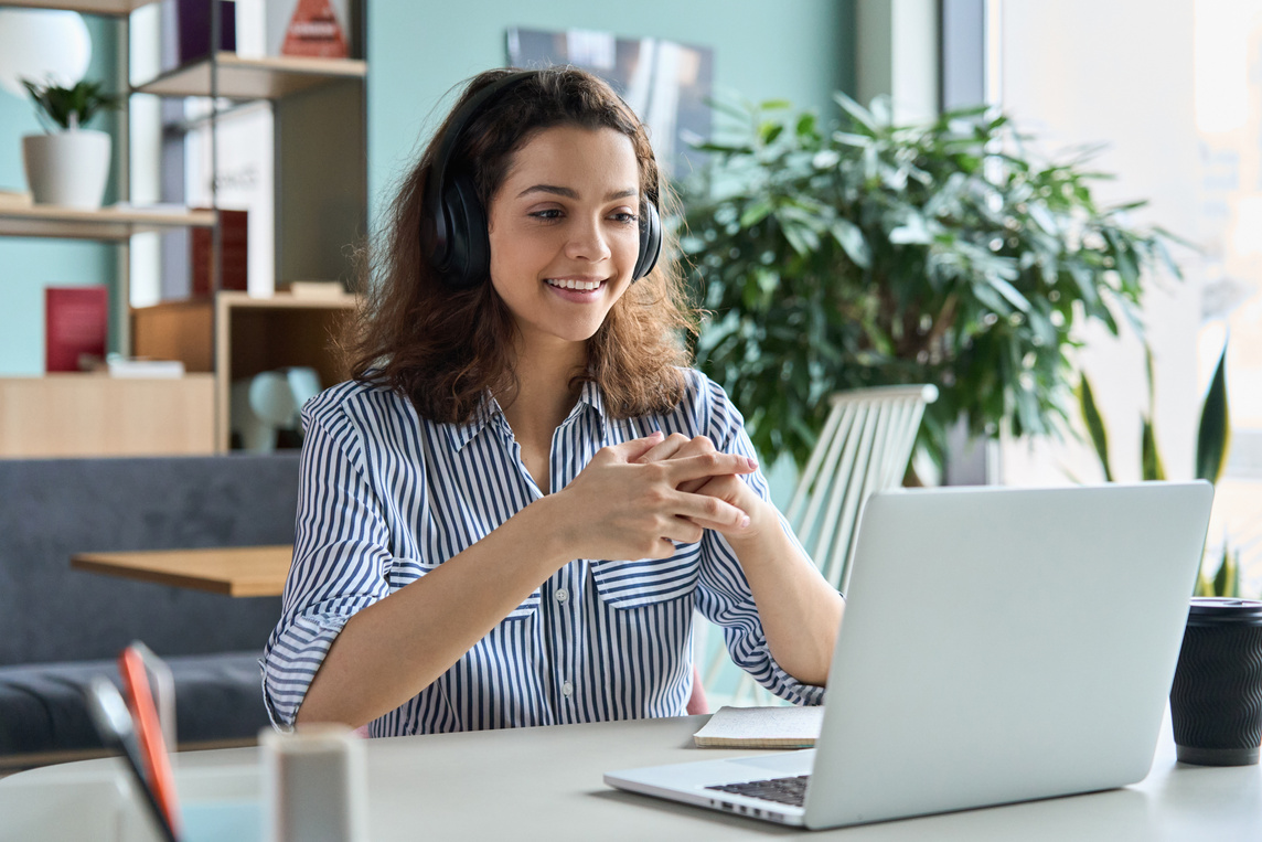  Female Student in Headphones Talking Online Using Laptop